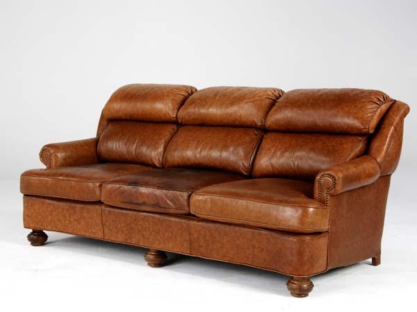 Appraisal: MODERN Leather sofa on bun feet with brass upholstery studs