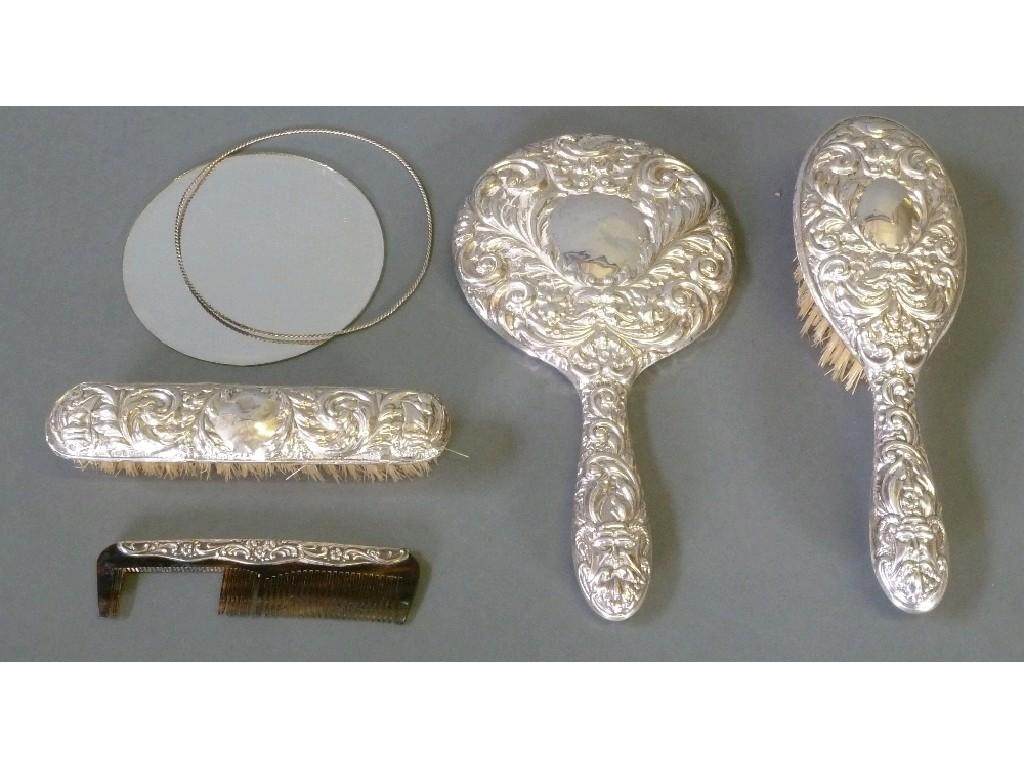 Appraisal: MODERN THREE PIECE EMBOSSED SILVER CLAD DRESSING TABLE HAND MIRROR