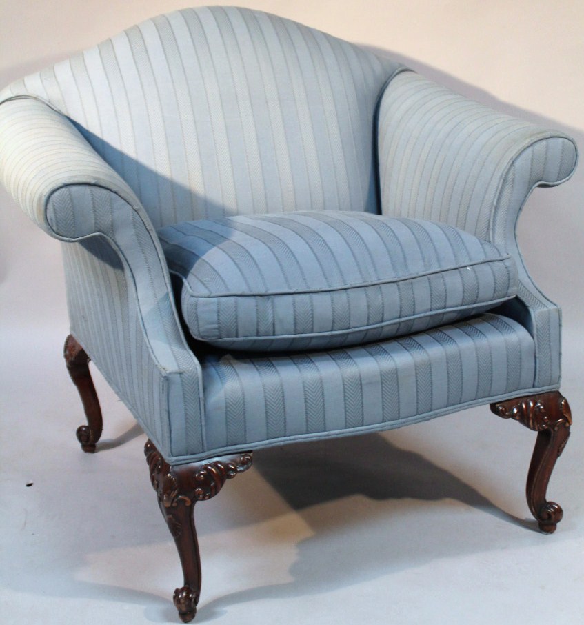 Appraisal: A deep seated armchair the shaped back and serpentine seat