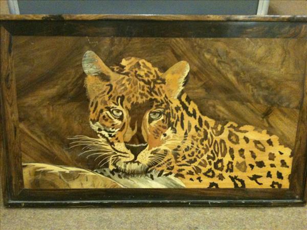 Appraisal: A walnut panel with marquetry inlaid recumbent leopard