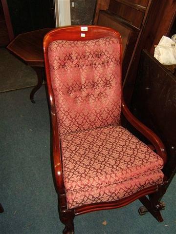 Appraisal: A Victorian mahogany rocking chair with scrolling arms wide