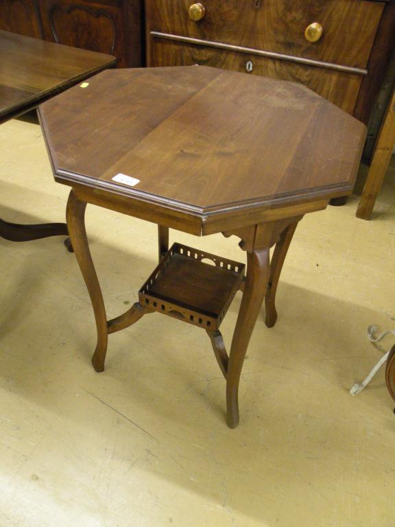 Appraisal: An Edwardian walnut two tier table with an octagonal top