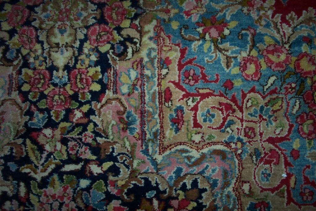 Appraisal: A large red ground wool carpet with polychrome and central