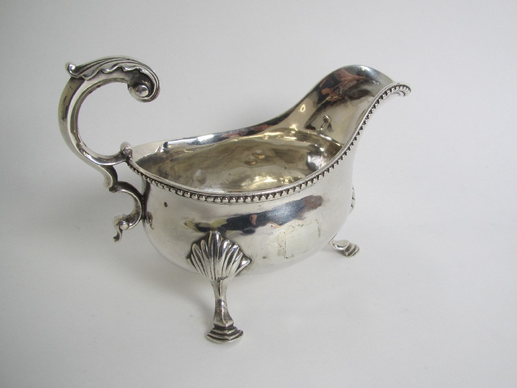 Appraisal: A silver sauceboat with gadroon rim double C scroll handle