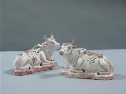 Appraisal: PAIR OF FRENCH FAIENCE COWS Each horned beast modeled seated