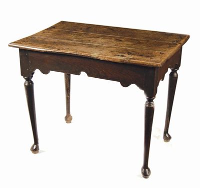 Appraisal: An oak centre table the boarded top above a shaped