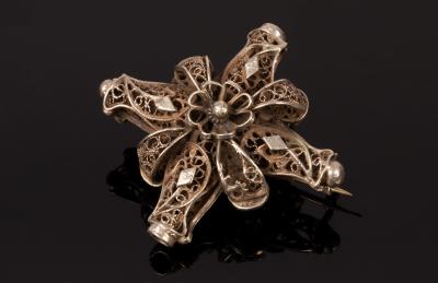 Appraisal: An Eastern white metal brooch of cross form the central