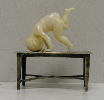 Appraisal: CARVED IVORY MINIATURE FIGURE OF A BOY Exercising on a