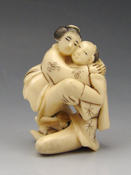 Appraisal: CARVED EROTIC IVORY SITTING COUPLE NETSUKE Couple in graphic sitting