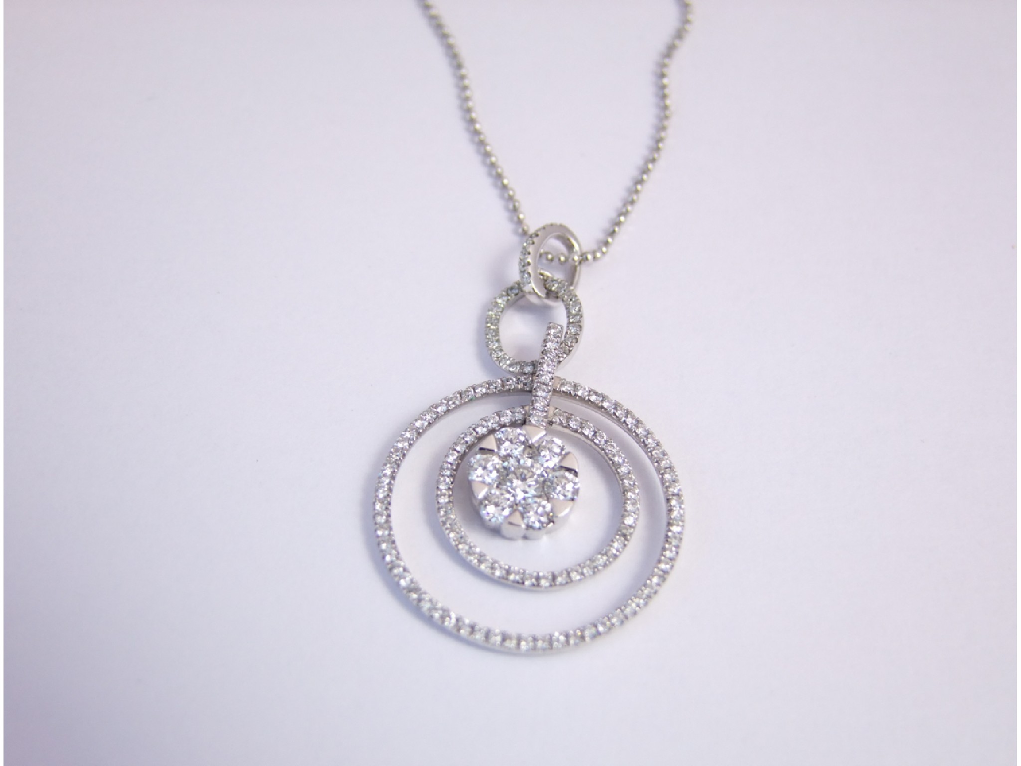 Appraisal: A diamond pendant centred with a round brilliant-cut diamond weighing