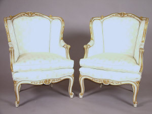 Appraisal: A pair of painted and parcel gilt wingback armchairs th