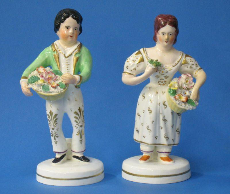 Appraisal: A PAIR OF STAFFORDSHIRE POTTERY CHILD GARDENER FIGURES modelled holding