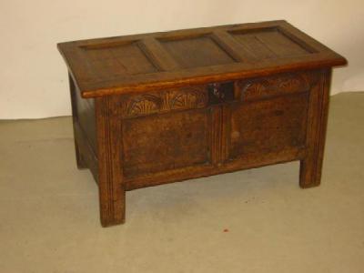 Appraisal: AN OAK PANELLED COFFER the hinged lid enclosing interior with