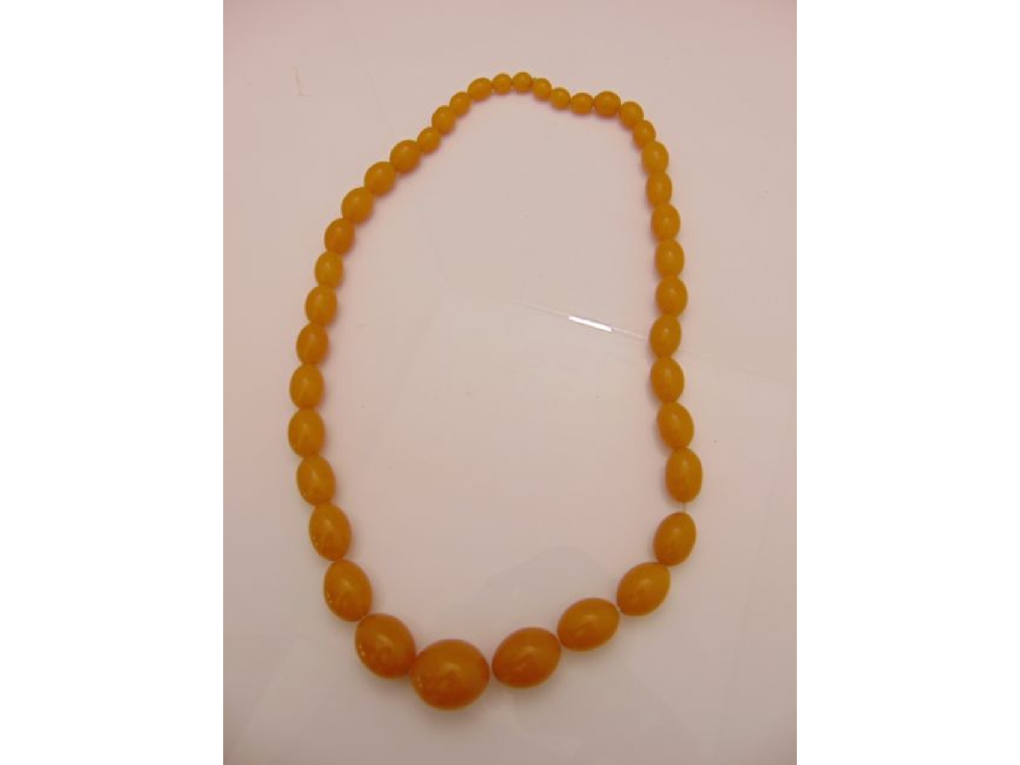 Appraisal: A graduated amber bead necklace g