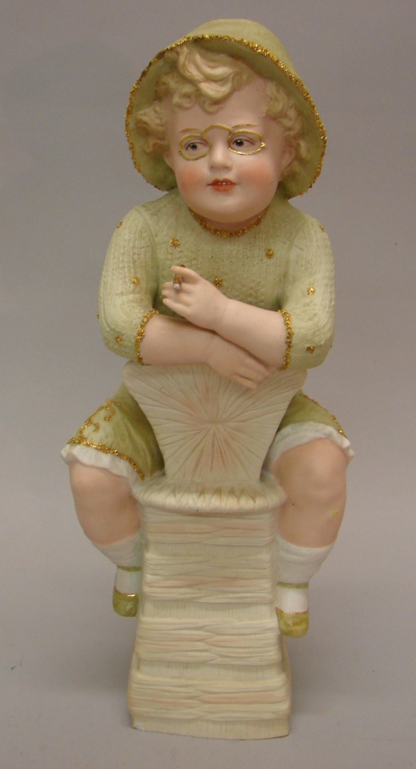 Appraisal: RWA Bisque figurine of male child sitting on a backwards