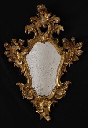 Appraisal: VENETIAN ROCOCO-STYLE CARVED GILTWOOD MIRROR The cartouche-shape plate within molded