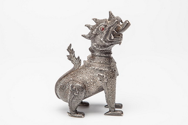 Appraisal: A BURMESE SILVER METAL DOG with ruby coloured eyes allover