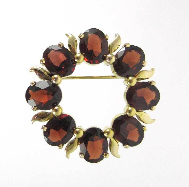 Appraisal: GARNET AND FOURTEEN KARAT GOLD BROOCH set with eight oval-cut