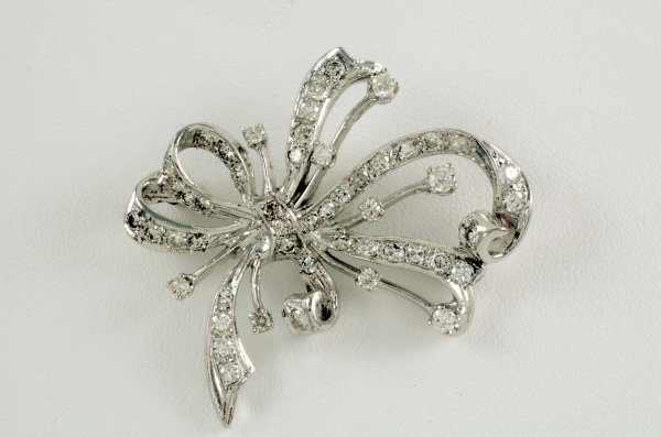 Appraisal: Diamond bow pin in approximately K white gold Fifty mm