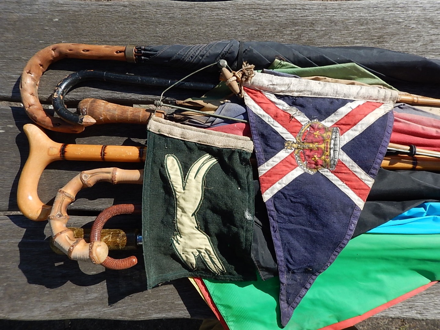 Appraisal: A collection of umbrellas walking sticks and two pennants one