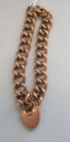 Appraisal: A gold curb link bracelet on a gold heart shaped