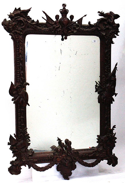 Appraisal: AN EASTERN CARVED HARDWOOD FRAMED WALL MIRROR with a crown