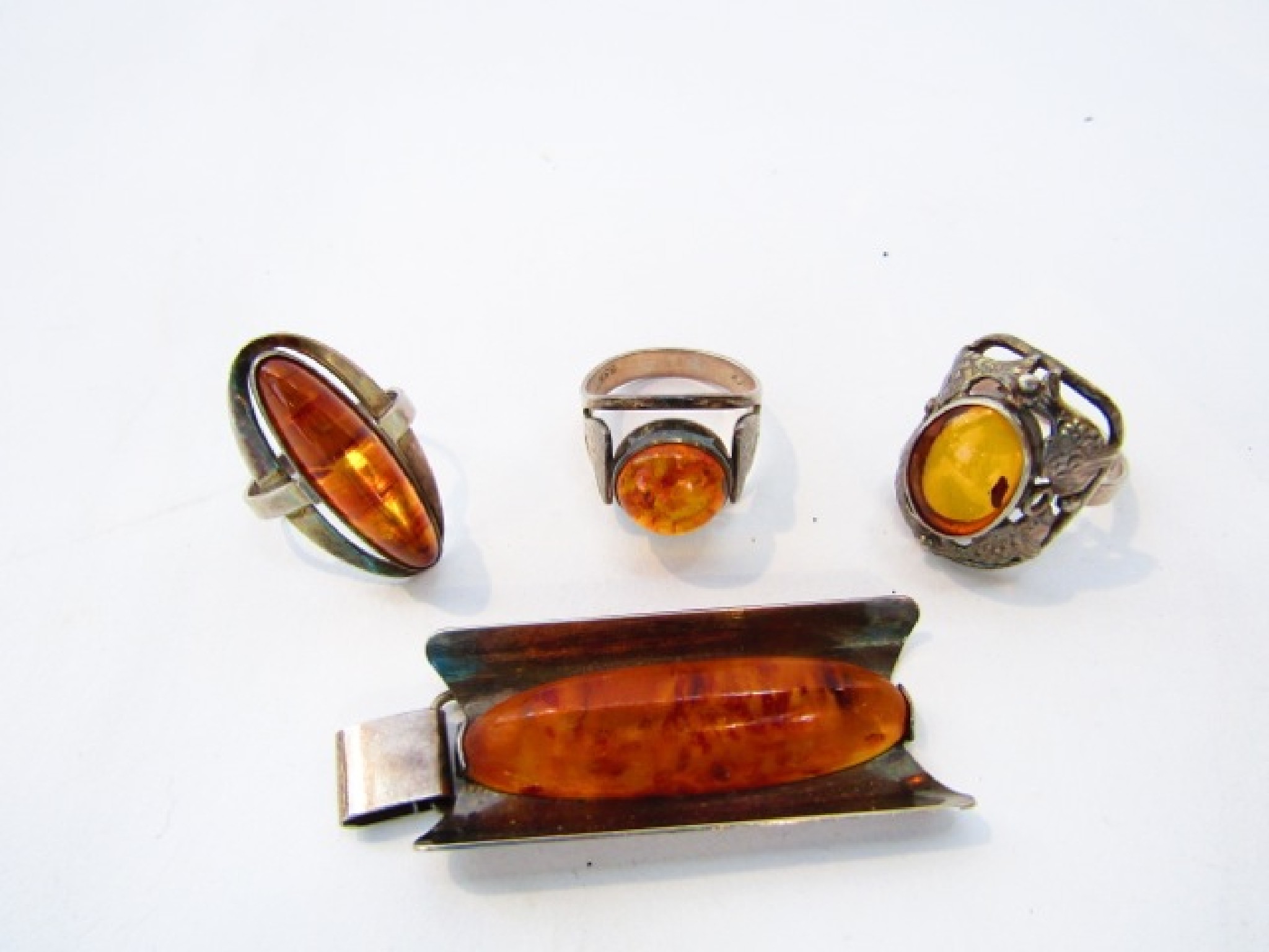 Appraisal: An amberoid ring with stylised fish border in silver two