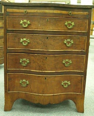 Appraisal: A mahogany serpentine front chest with brushing slide fitted four