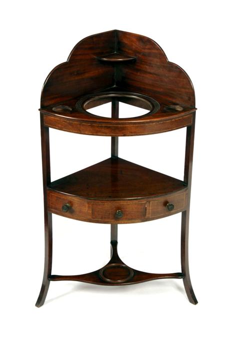 Appraisal: A th century mahogany corner wash stand with graduated splash