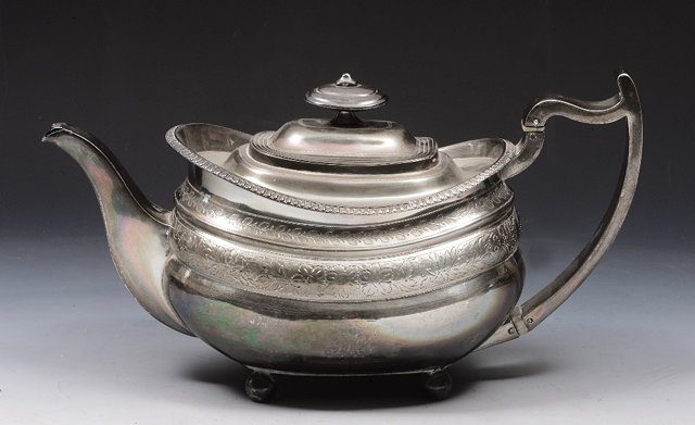 Appraisal: A GEORGIAN OVAL SHAPED SILVER TEAPOT with foliate engraved decoration