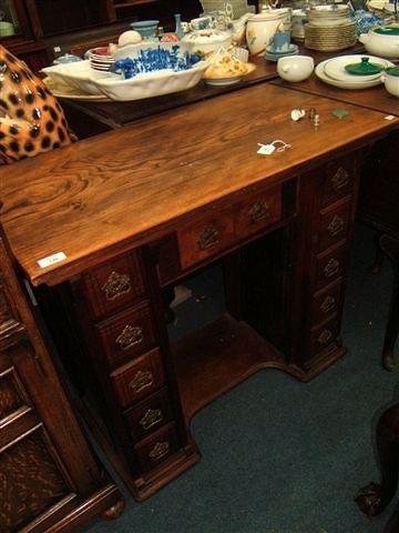 Appraisal: A small kneehole desk with a variety of drawers wide