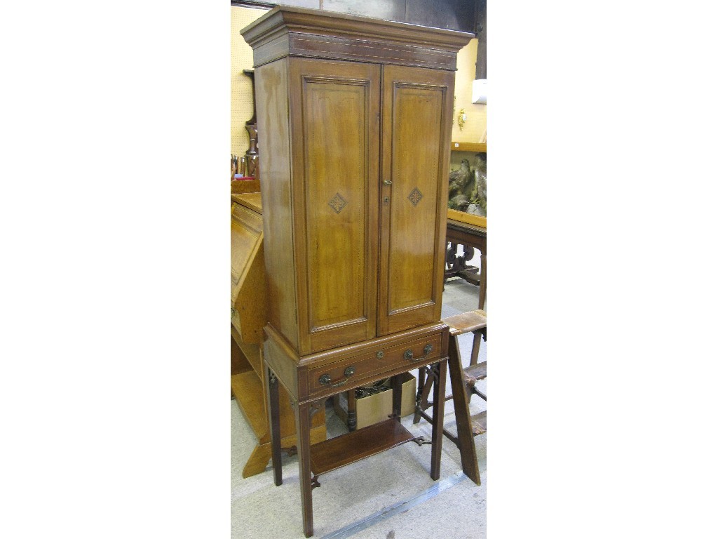 Appraisal: Mahogany and inlaid cabinet on a stand the interior fitted