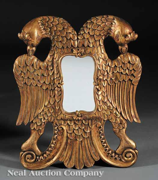 Appraisal: A Continental Carved and Gilded Mirror double eagle winged frame