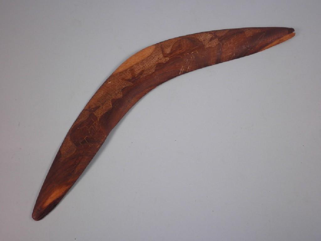 Appraisal: A hardwood boomerang carved in relief with ostriches and kangaroos