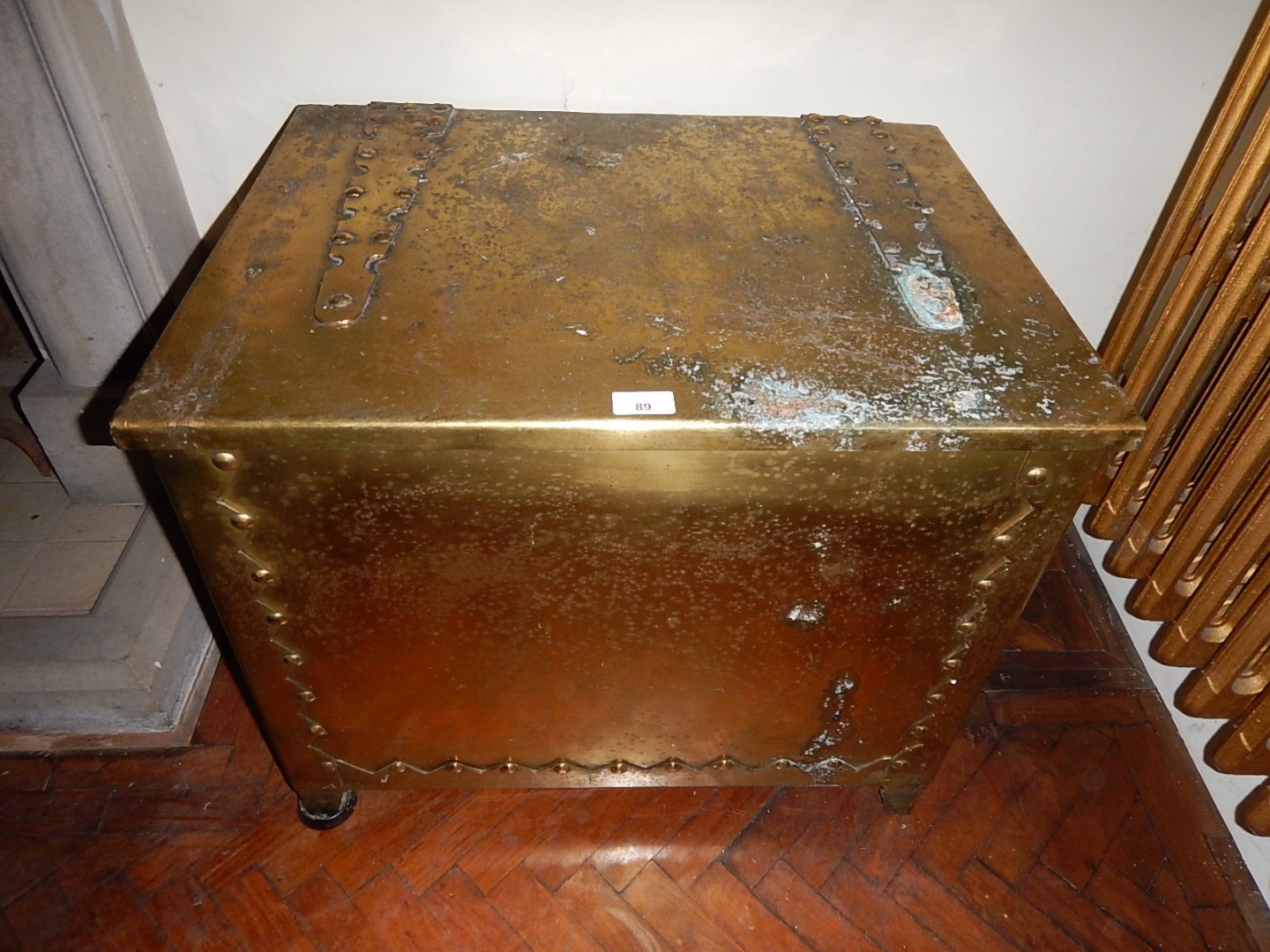 Appraisal: A brass coal box with hinged lid and riveted strap