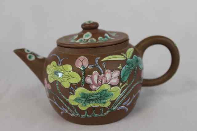 Appraisal: A YIXING TEAPOT with polychrome enamel decoration of flower designs