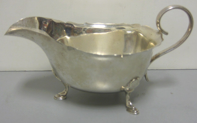 Appraisal: MAPPIN WEBB SHEFFIELD English silver sauce boat tri-hoof-footed scroll handle