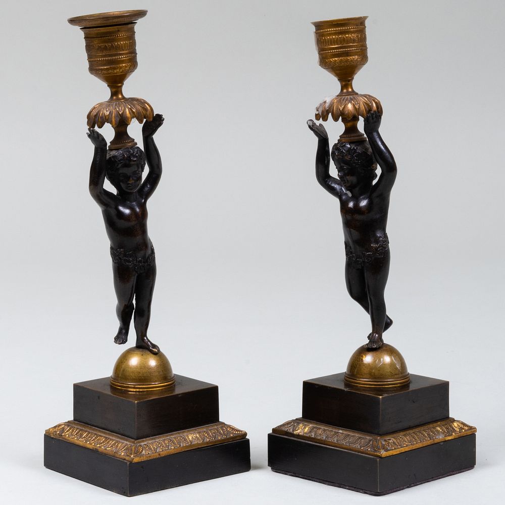 Appraisal: Pair of Patinated Metal Candlesticks with Putti Supports x x