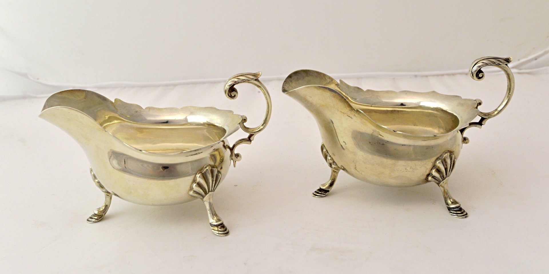 Appraisal: A pair of silver sauceboats each having a shaped rim