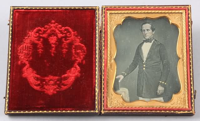 Appraisal: Quarter plate daguerreotype of man knees up wearing quasi-uniform with