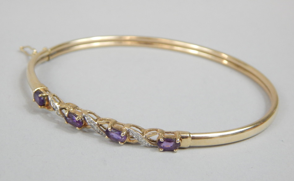 Appraisal: A ct gold bangle set with purple and white stones