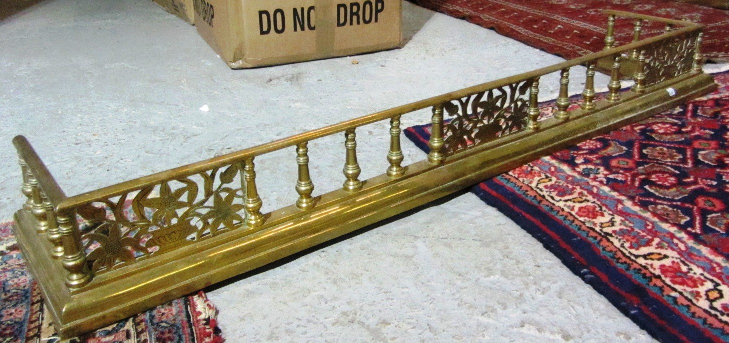 Appraisal: A mahogany framed footstool and a brass fire fender