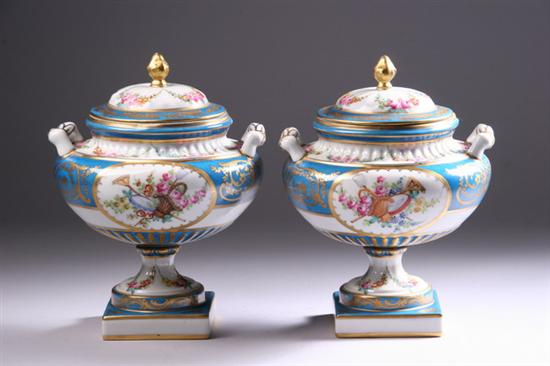 Appraisal: PAIR S VRES-STYLE PORCELAIN COVERED FOOTED URNS late th-early th