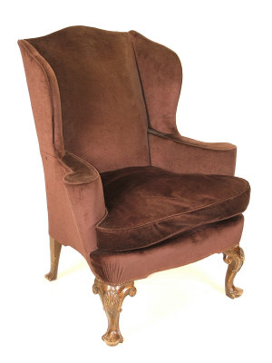 Appraisal: A brown upholstered wing armchair th century upon walnut shell