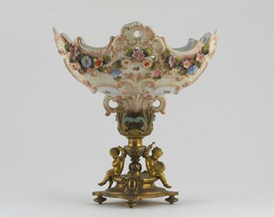 Appraisal: A Continental porcelain rococo moulded centrepiece encrusted with flowerheads the