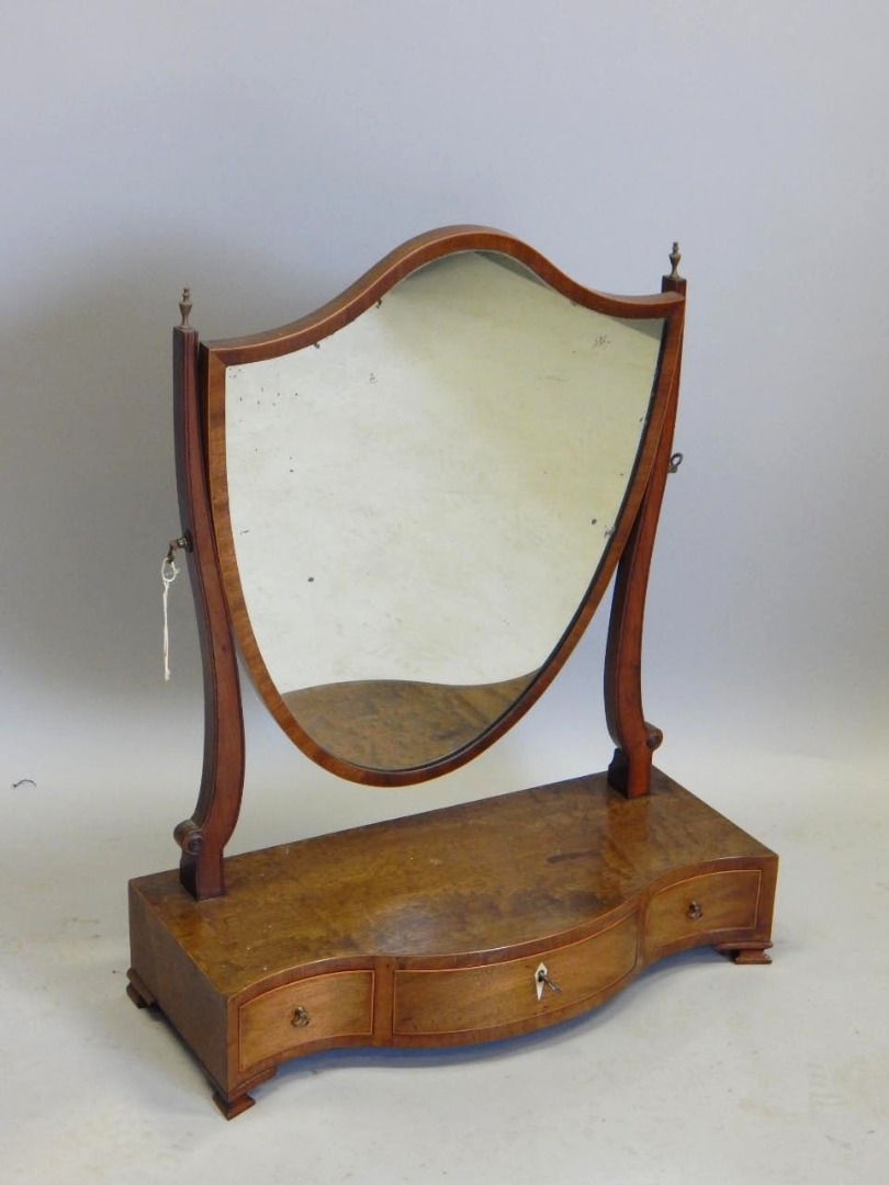 Appraisal: A mahogany dressing table mirror with shield shape plate on