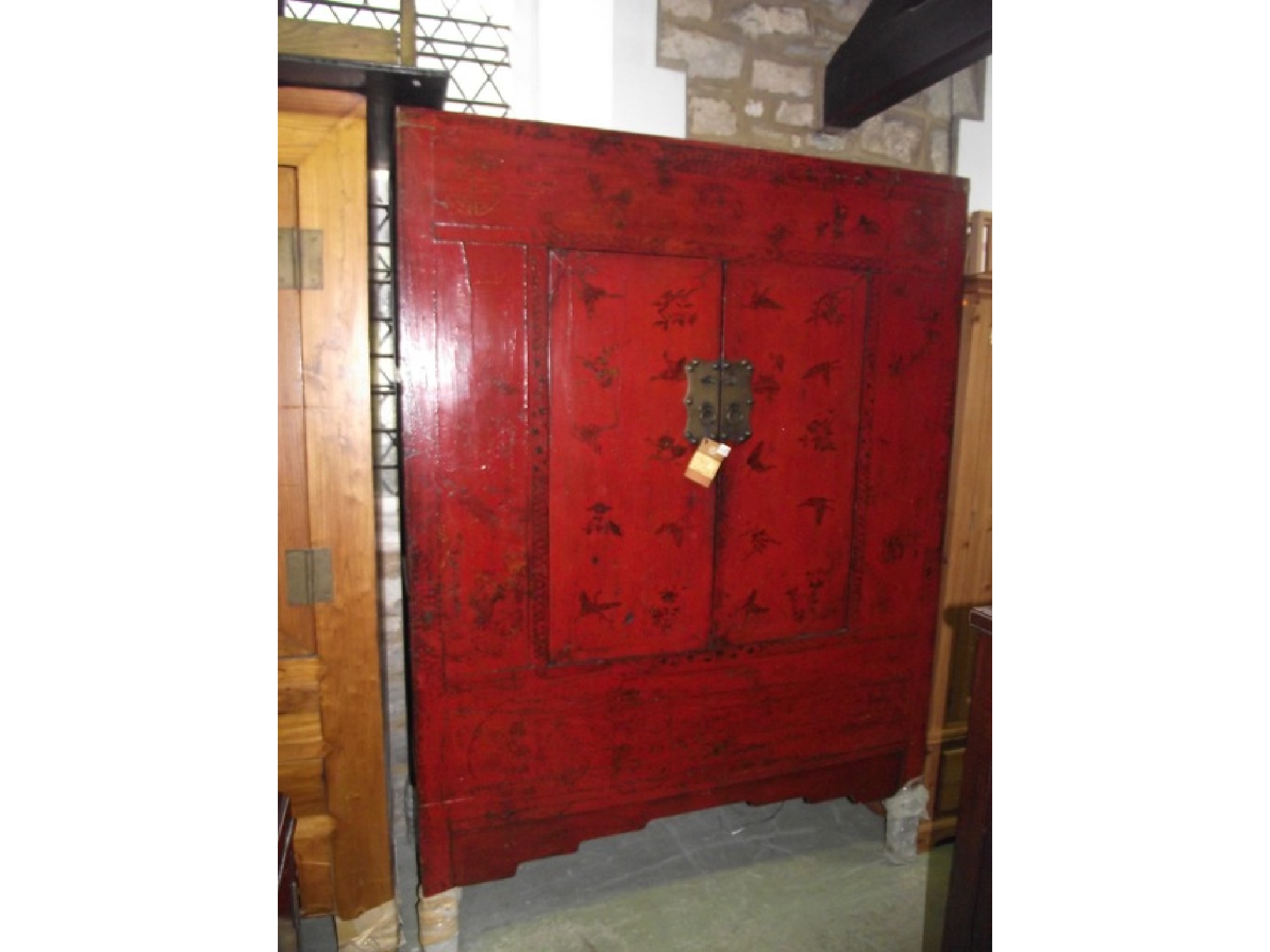 Appraisal: A Chinese red stained wardrobe with chinoiserie detail enclosed by