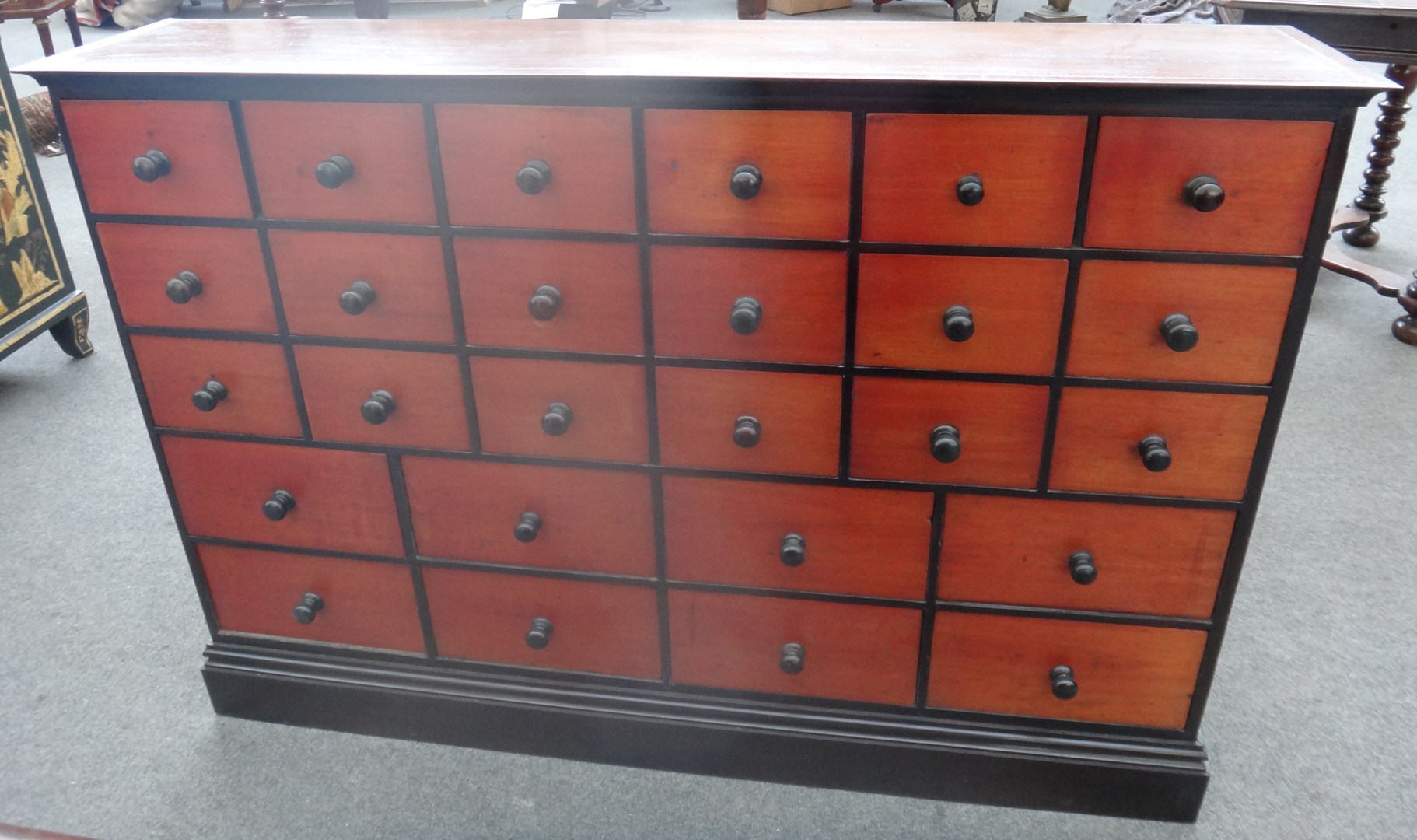 Appraisal: A mahogany pine and ebonised twenty six drawer apothecary cabinet