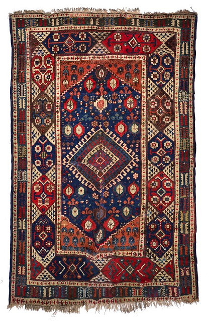 Appraisal: A KURDISH RED GROUND RUG with a central hooked diamond