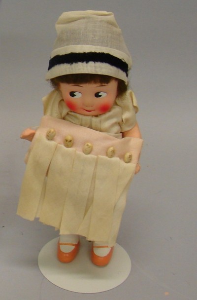 Appraisal: Unmarked papier mache nurse holding quints on a pillow This